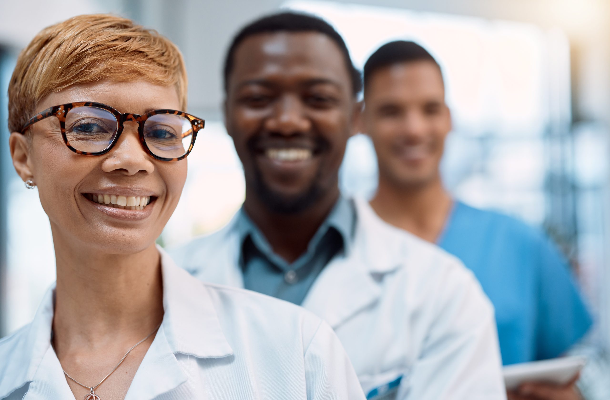 Black woman, portrait and doctors smile for teamwork, healthcare leadership and hospital management. Group, happy medical employees and face of clinic collaboration, surgery trust or medicine support